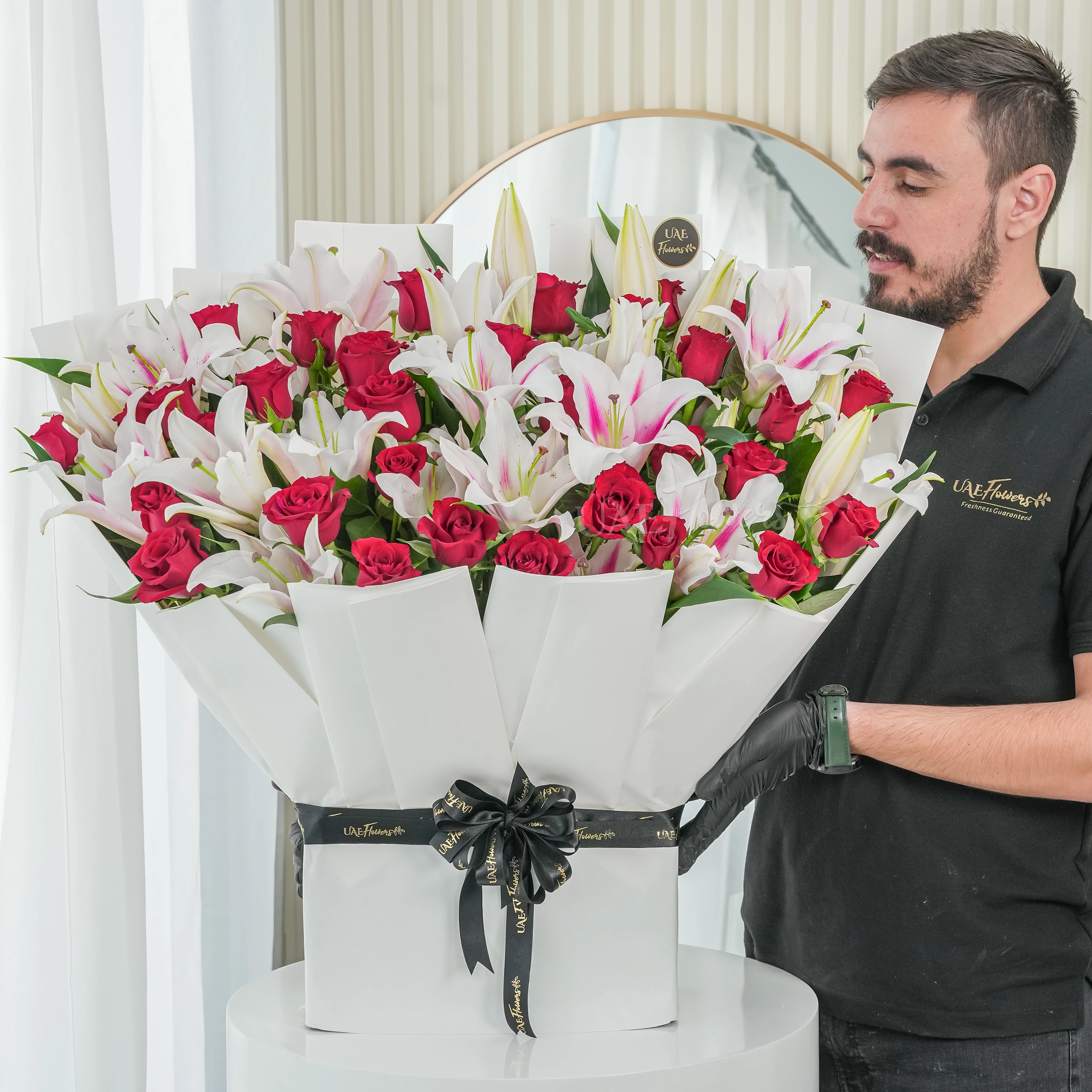 Bouquet of 10 pink lilies and 30 red roses with green fillers tied with ribbons.