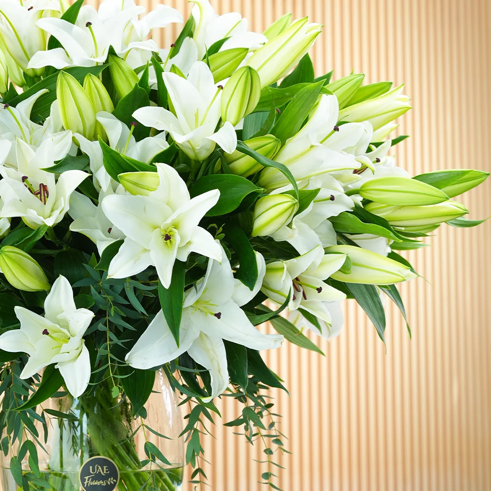 glass vase with 20 white lilies and green fillers