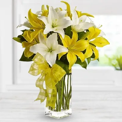 10 white & yellow lilies in a glass vase