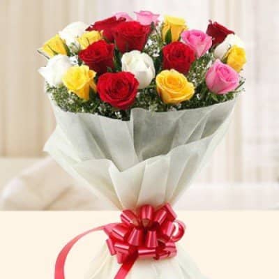 Roses Shower - Bouquet of 12 mixed roses in red, white, yellow, and pink with fillers, wrapped in decorative paper and finished with a red ribbon – cheerful gift by UAE Flowers.