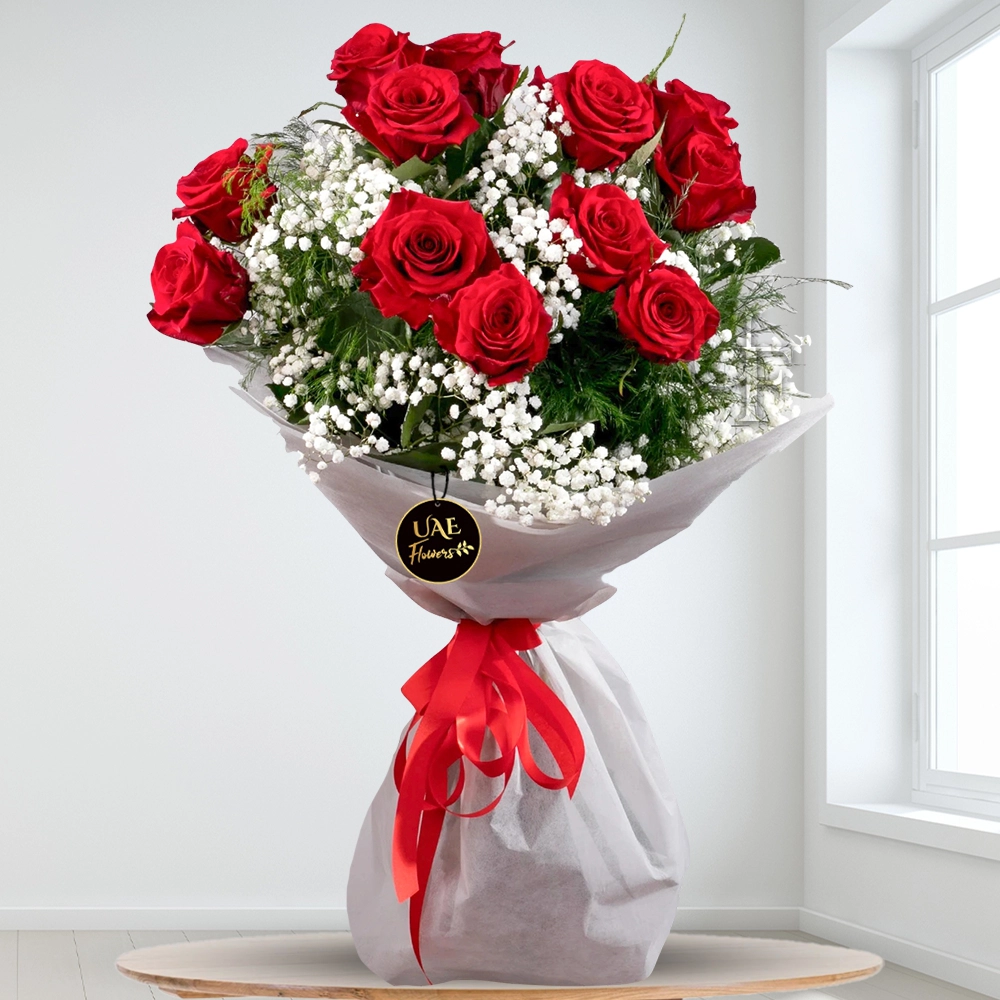 Romantic Red - Bouquet of 12 red roses with baby’s breath and greenery wrapped in white paper and tied with a red ribbon
