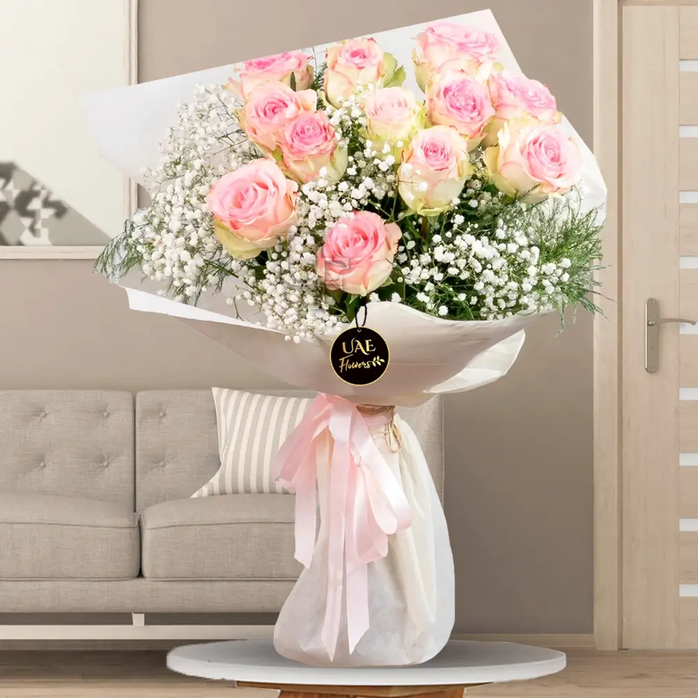 12 pink roses nestled among plenty of soft baby breath