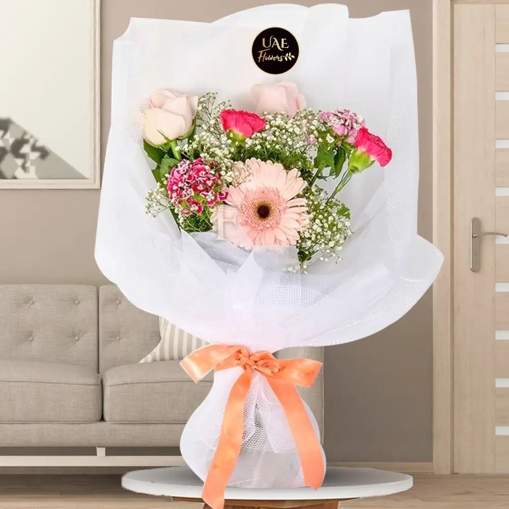 Beautifully wrapped bouquet with light pink roses, pink gerbera, dark pink carnations, sweet william, baby's breath, and tea leaf – perfect for elegant gifting.