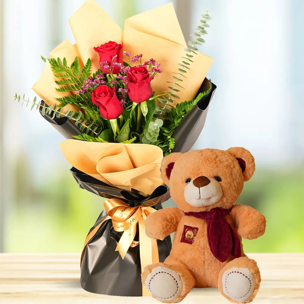 bouquet of 3 red roses in wrapping paper with a small teddy