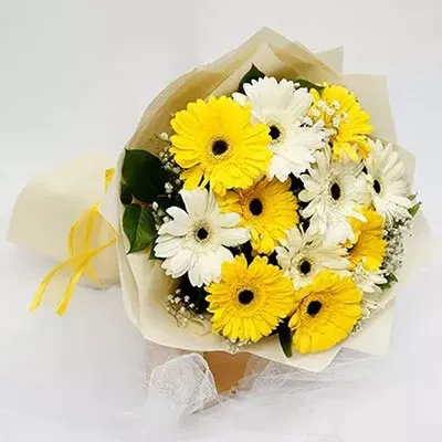 Bouquet of yellow and white gerberas with seasonal fillers wrapped in elegant paper