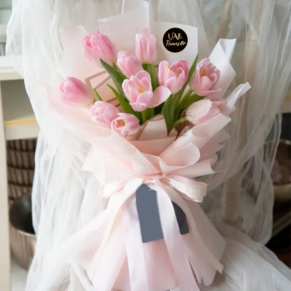 10 pink tulips in pink wrapping paper tied with pink ribbon