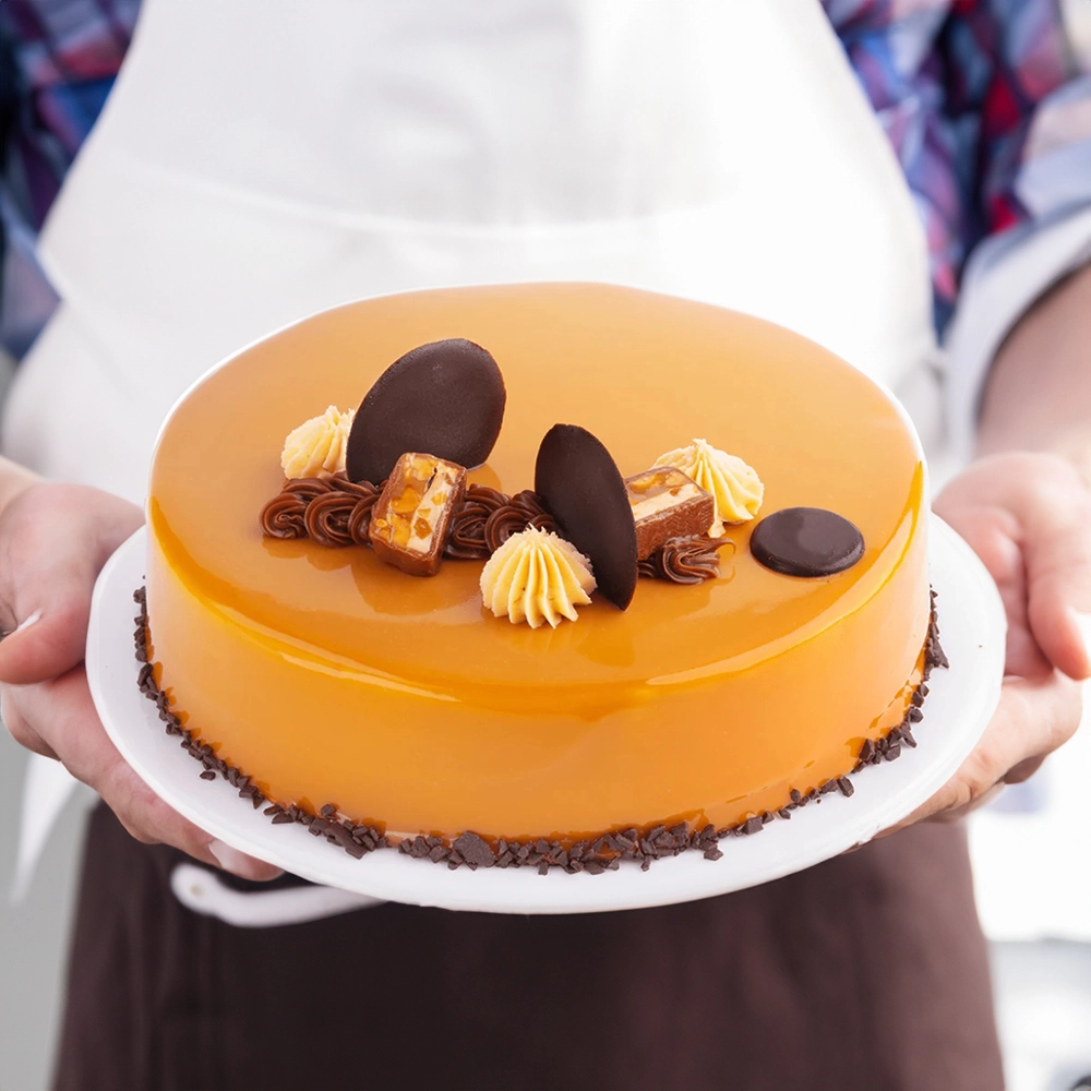1 kg Snickers Cake with 4 pink lily stems and a pack of Snickers Minis.