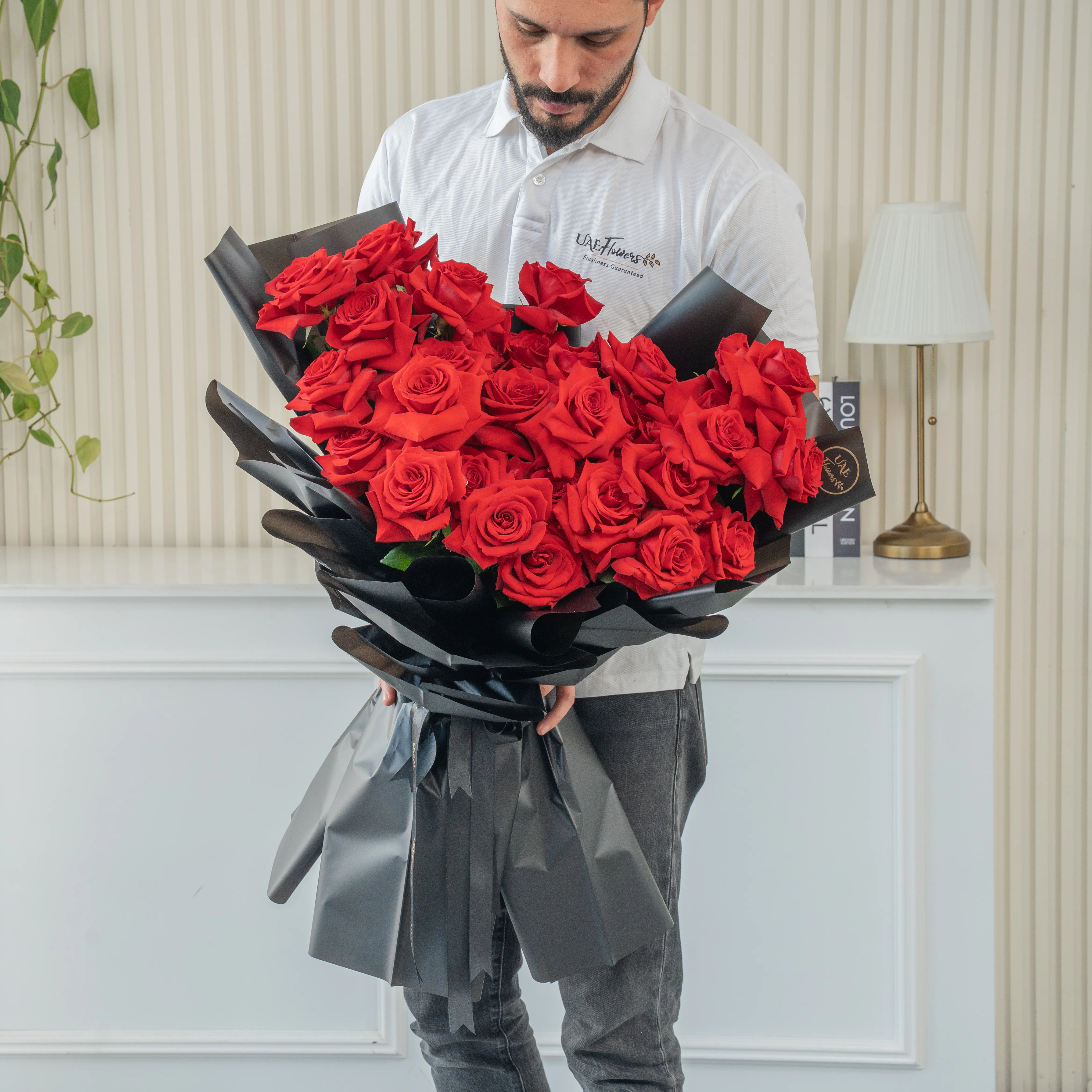 Bouquet of 25 red roses in black paper packing