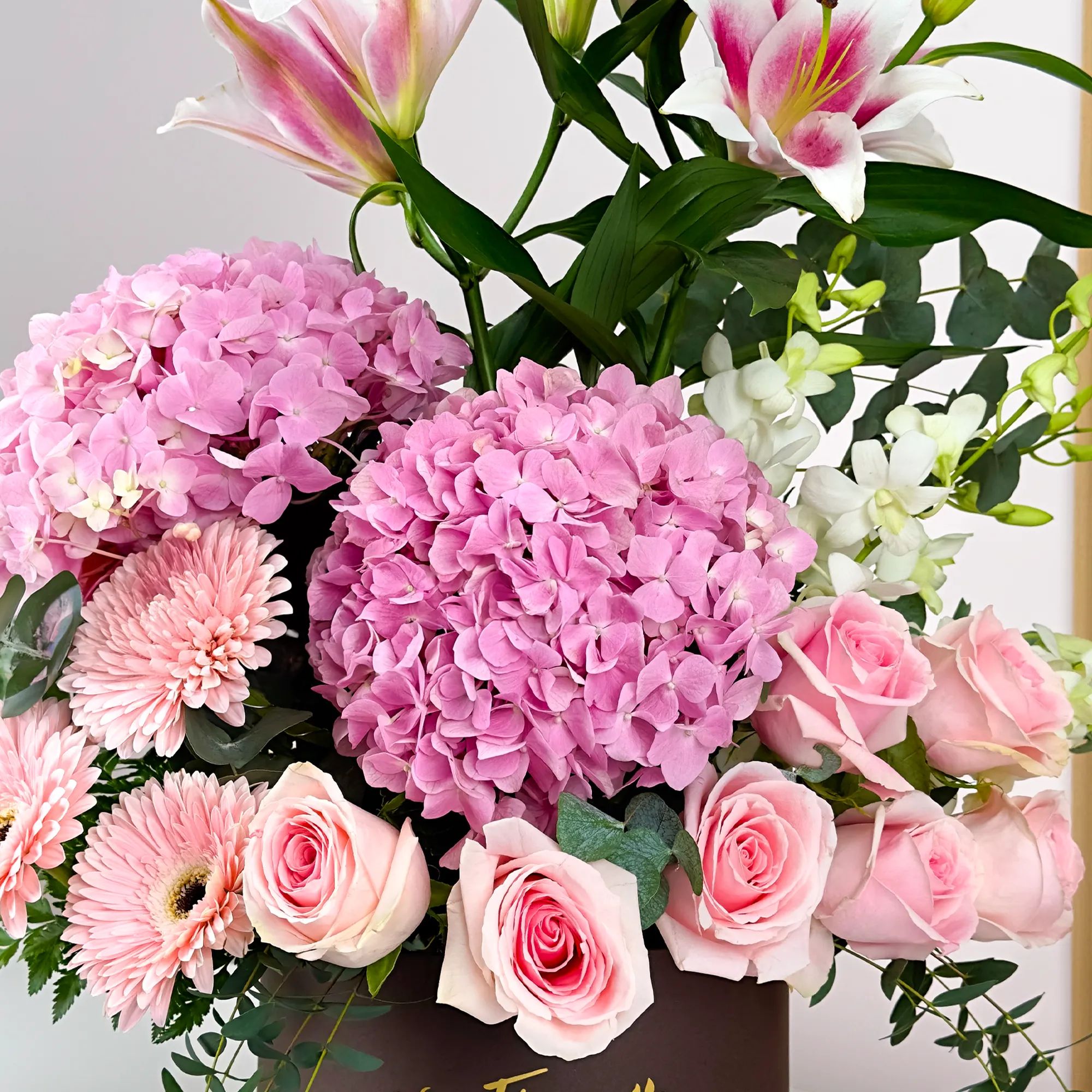 2 pink hydrangeas, 2 pink lilies, 10 pink roses, 3 pink gerberas, and 5 white orchids